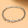 Silver braided bracelet on a beige background