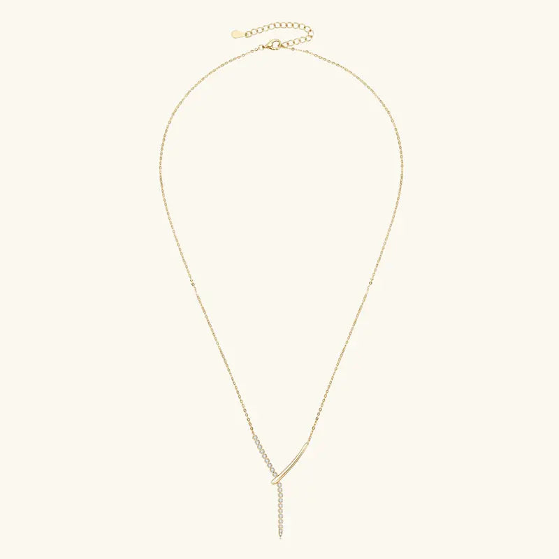 Gold necklace on a light beige background