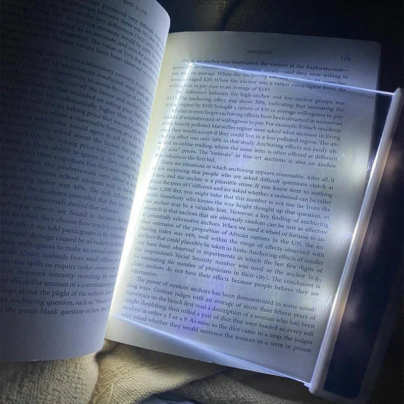Ultra-slim LED page reading light illuminating an open book, portable acrylic book lamp for night reading.
illuminated page of the book with clear screen placed on the top of the page