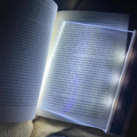 Ultra-slim LED page reading light illuminating an open book, portable acrylic book lamp for night reading.
illuminated page of the book with clear screen placed on the top of the page