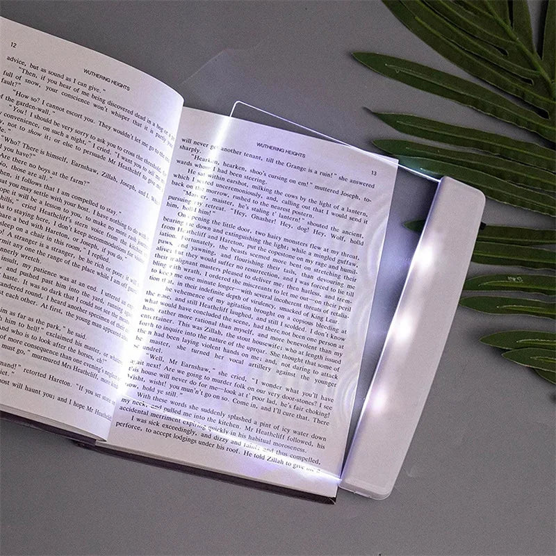 Ultra-slim LED page reading light illuminating an open book, portable acrylic book lamp for night reading.
led screen on top of book page, illuminating page