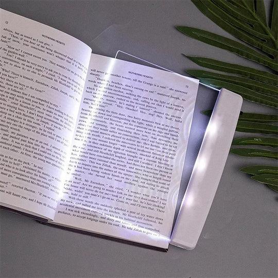 Ultra-slim LED page reading light illuminating an open book, portable acrylic book lamp for night reading.
led screen on top of book page, illuminating page