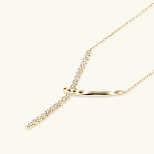 Gold necklace with a curved design and small crystals on a white background